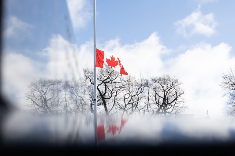 The sky and clouds are reflected off of the Queen Victoria statue as the Canadian flag hangs at half-mast at the legislature in Victoria, B.C., on Wednesday, Feb. 11, 2026 in honour of the victims in the mass shooting in Tumbler Ridge, B.C. THE CANADIAN PRESS/Chad Hipolito