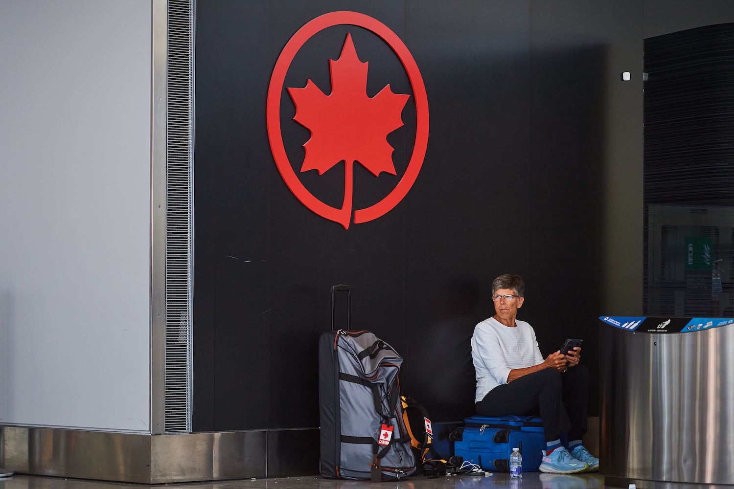 A traveller waits by the Air Canada departure gates as flight attendants picket at Pearson International Airport in Toronto, on Monday, Aug. 18, 2025. THE CANADIAN PRESS/Sammy Kogan.