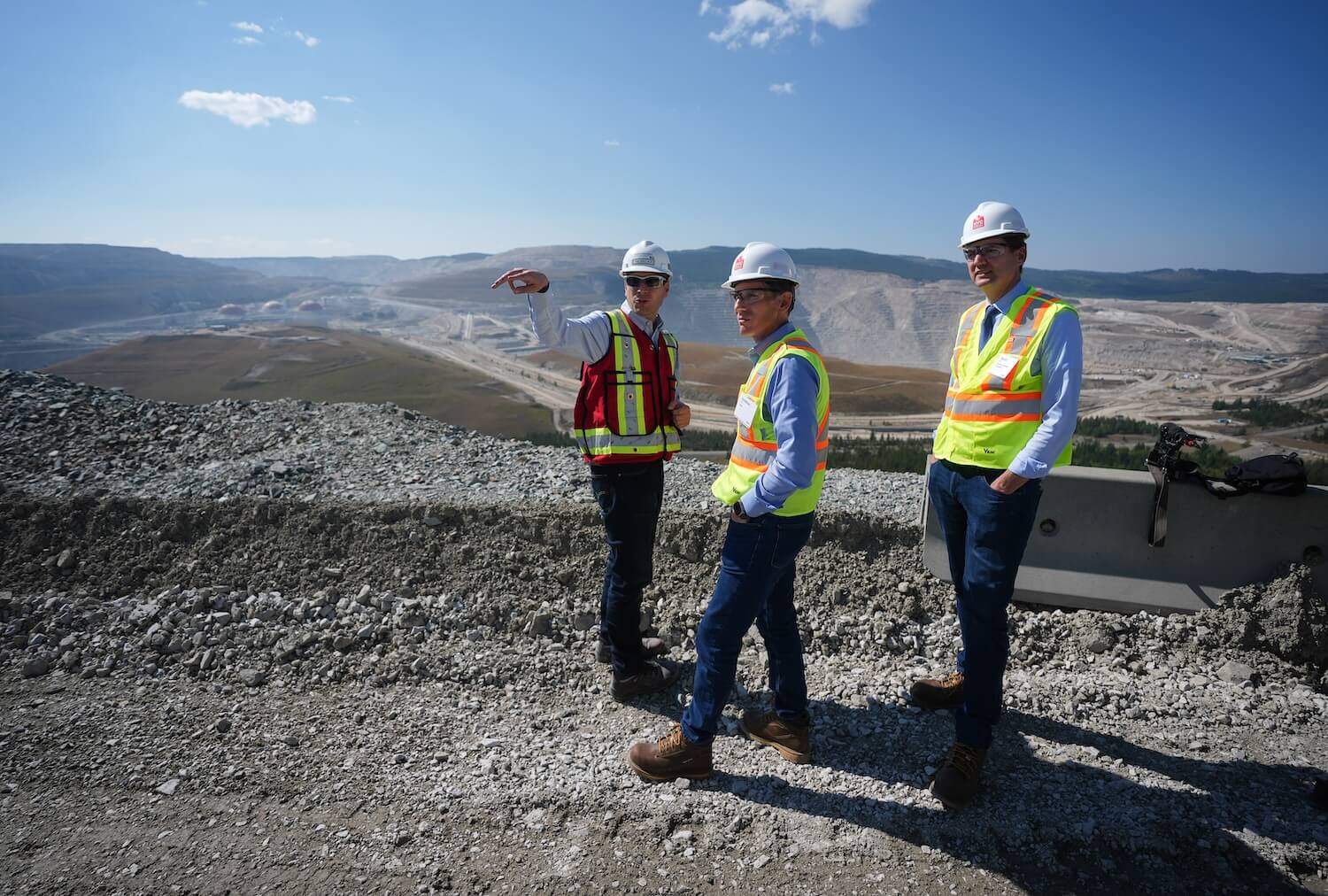 B.C. Premier David Eby, right, and Teck Resources President and CEO Jonathan Price, centre, listen to Highland Valley Copper Operations general manager Phil Wallace, left, as they view the mine from a lookout, near Logan Lake, B.C., on Thursday, September 11, 2025. Teck Resources marked the start of construction on the Highland Valley Copper Mine Life Extension project that will extend the life of Canada's largest copper mine from 2028 to 2046. THE CANADIAN PRESS/Darryl Dyck